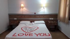 居姆贝特欧祖卡拉1号公寓式酒店的一张写在上面的床上,上面写着你喜欢的字眼