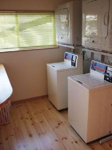 阿苏市阿苏巴瑟背包客酒店的一间厨房,在房间内配有2台洗衣机和烘干机