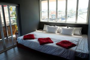 班拉克海滩滨海住宅酒店的一间卧室配有一张带两个红色枕头的床