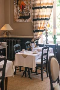 蒙特利马尔花园酒店的一间带2张桌子和椅子的用餐室以及窗户。