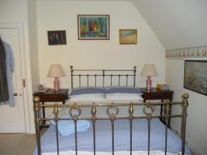 艾尔斯伯里Mayertorne Cottage的一间卧室配有一张带2个床头柜和2盏灯的床。