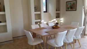 马拉喀什Marrakech Pearl的一间带木桌和白色椅子的用餐室