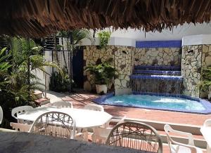 巴拉奥纳省圣克鲁斯卡里布酒店的一个带桌椅的游泳池和一个喷泉