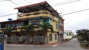 巴克里索莫雷诺港Hostal Dorys Mar的街道上带阳台的黄色建筑
