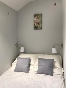 Ballymore EustaceHobbit Hollow的一间卧室配有带2个枕头和2盏灯的床