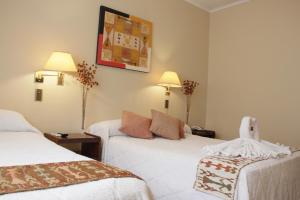圣达菲Hotel Bertaina的酒店客房,配有两张床和椅子