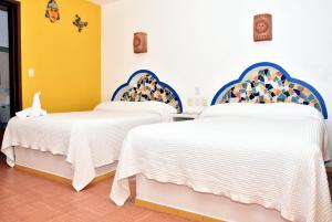 科苏梅尔玛丽卡门酒店的白色和蓝色的客房内的两张床