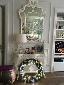 托伦蒂诺Luxury My home的一张带镜子和手腕花圈的白色桌子
