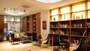 首尔格拉莫斯酒店的图书馆配有椅子、桌子和书架
