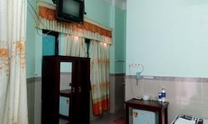 广义迈迈酒店的一间墙上配有电视的房间