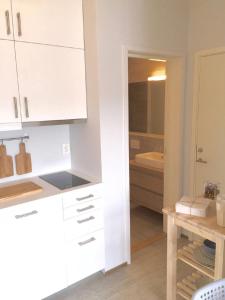 卑尔根Knudsen Apartment的厨房配有白色橱柜和水槽