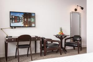 贝尔法斯特贝尔法斯特泰坦尼克酒店的客房设有桌子、椅子和电视。
