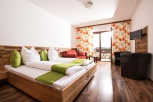 里格斯堡瑞吉尔斯伯格尔豪夫酒店的一间卧室配有一张带绿色和白色枕头的大床