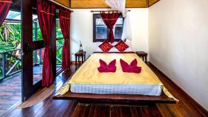 高兰果树宾馆的一间卧室配有一张带红色枕头的床