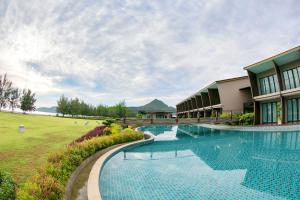 三百岭La Isla Pranburi Beach Resort的一座带游泳池的度假村,位于一座建筑旁边