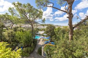 伊斯基亚维多利亚酒店的享有带游泳池和树木的度假村景色