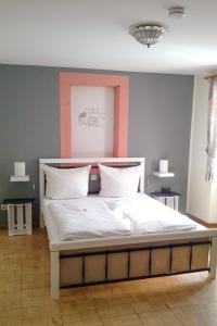 莱温Weinhaus Kurtrierer Hof的一间卧室配有一张带白色床单的大床