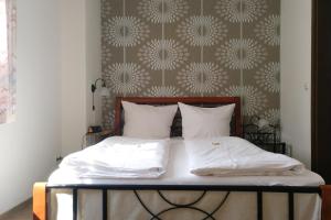 莱温Weinhaus Kurtrierer Hof的卧室内的一张带白色床单和枕头的床