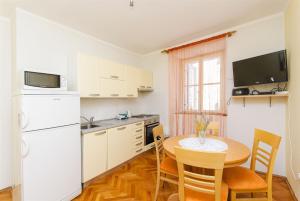 尼亚卢卡Apartment Kampanel的厨房配有桌子和白色冰箱。