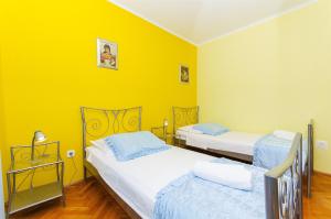 尼亚卢卡Apartment Kampanel的黄色墙壁客房的两张床
