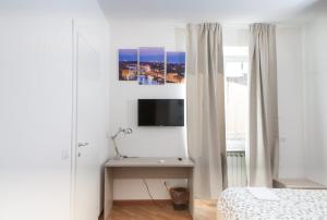 佛罗伦萨Le Tre Lune Suites的一间卧室配有一张床和一张书桌及电视