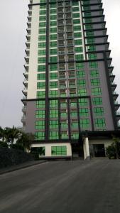 乔木提恩海滩Dusit Grand Condo View Apartment的一座高大的建筑,旁边设有绿色窗户