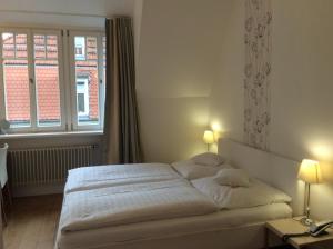 海德堡海德堡阿斯托利亚酒店的卧室配有白色的床和窗户。