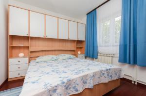 普纳特Apartment Bozena的一间卧室配有一张带蓝色窗帘的大床