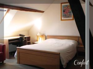 塞扎讷Logis Le Relais Champenois的一间卧室配有一张床和一张书桌