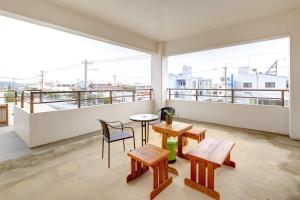 冲绳岛市青山公寓的带阳台的带桌椅的房间