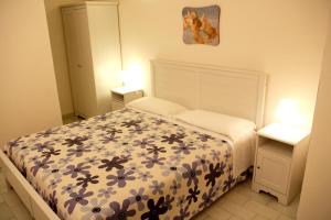 萨维勒特里Midiè B&B Savelletri的一间卧室配有一张带花卉床罩的床