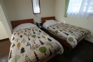 富士河口湖五月女王度假屋的卧室内两张并排的床