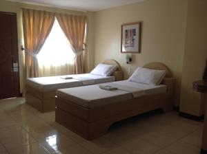 独鲁万丹内尔潘系娜内酒店的酒店客房设有两张床和窗户。