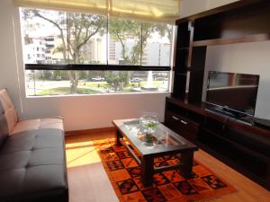 利马Miraflores Bello Apartamento的带沙发和大窗户的客厅