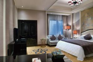 武汉武汉天禄华美达广场酒店的一间卧室配有一张床、一台电视和一张沙发