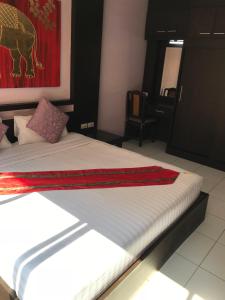 芭堤雅市中心ZIP Hotel & Restaurant的一间卧室配有一张床铺,床上铺有红色毯子