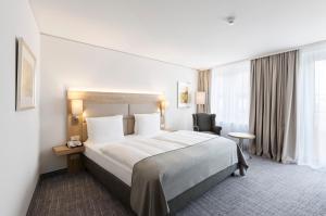 纽伦堡Holiday Inn Nürnberg City Centre, an IHG Hotel的酒店客房带一张大床和一把椅子