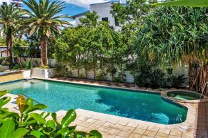 黄金海岸因迪格蓝色公寓式酒店的棕榈树庭院内的游泳池