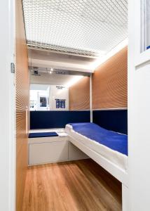 奥里奥阿塞里奥Resting Pods - ZZZleepandGo BGY Airport的一间卧室设有双层床和蓝色的墙壁。