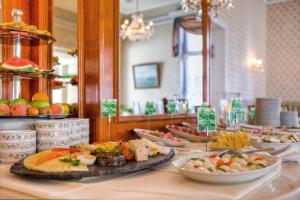 黑灵斯多夫SEETELHOTEL Villa Esplanade mit Aurora的餐桌上的自助餐,包括盘子