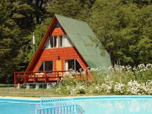 拉斯特朗卡斯Cabañas Pachapulay的游泳池旁带斜屋顶的小小屋