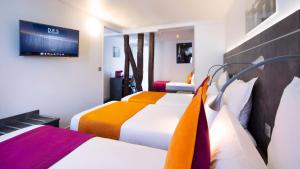 巴黎Hôtel du Plat d'Etain的酒店客房设有两张床和一台平面电视。