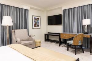 新奥尔良荣格酒店的酒店客房配有一张床、一张桌子和一把椅子。