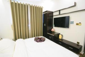 海防范汉酒店的卧室配有白色的床和电视。