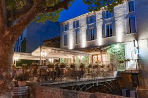 科洛布里埃Hotel Restaurant des Maures的大楼前设有桌椅的餐厅