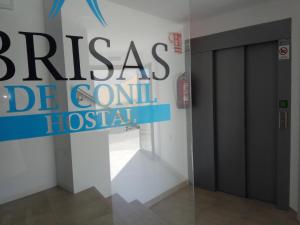 科尼尔-德拉弗龙特拉Hostal Brisas de Conil的一间房间里读过铜锣排泄医院的标志