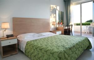 伊斯基亚罗蕾莱酒店的一间卧室配有一张带绿毯的大床
