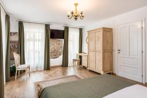 锡比乌阿斯特诺姆民宿的一间卧室配有一张床、一张书桌和一个吊灯。