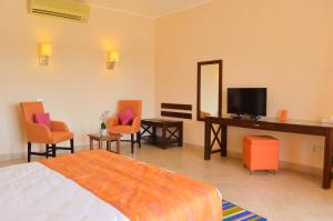 赫尔格达万岁蓝度假村和沙姆沙伊赫纳加潜水酒店（仅限成年人）的卧室配有床、电视和椅子