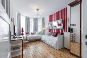 柏林Elegantes 2-Zimmer-Apartment im Kiez von Prenzlauer Berg的卧室配有白色的床和红色及白色条纹墙